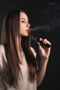 visage-jeune-femme-vaping-au-studio-noir